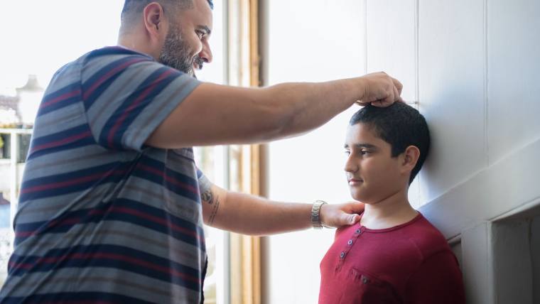 Measuring a child's height against the wall — growth and development checks for children